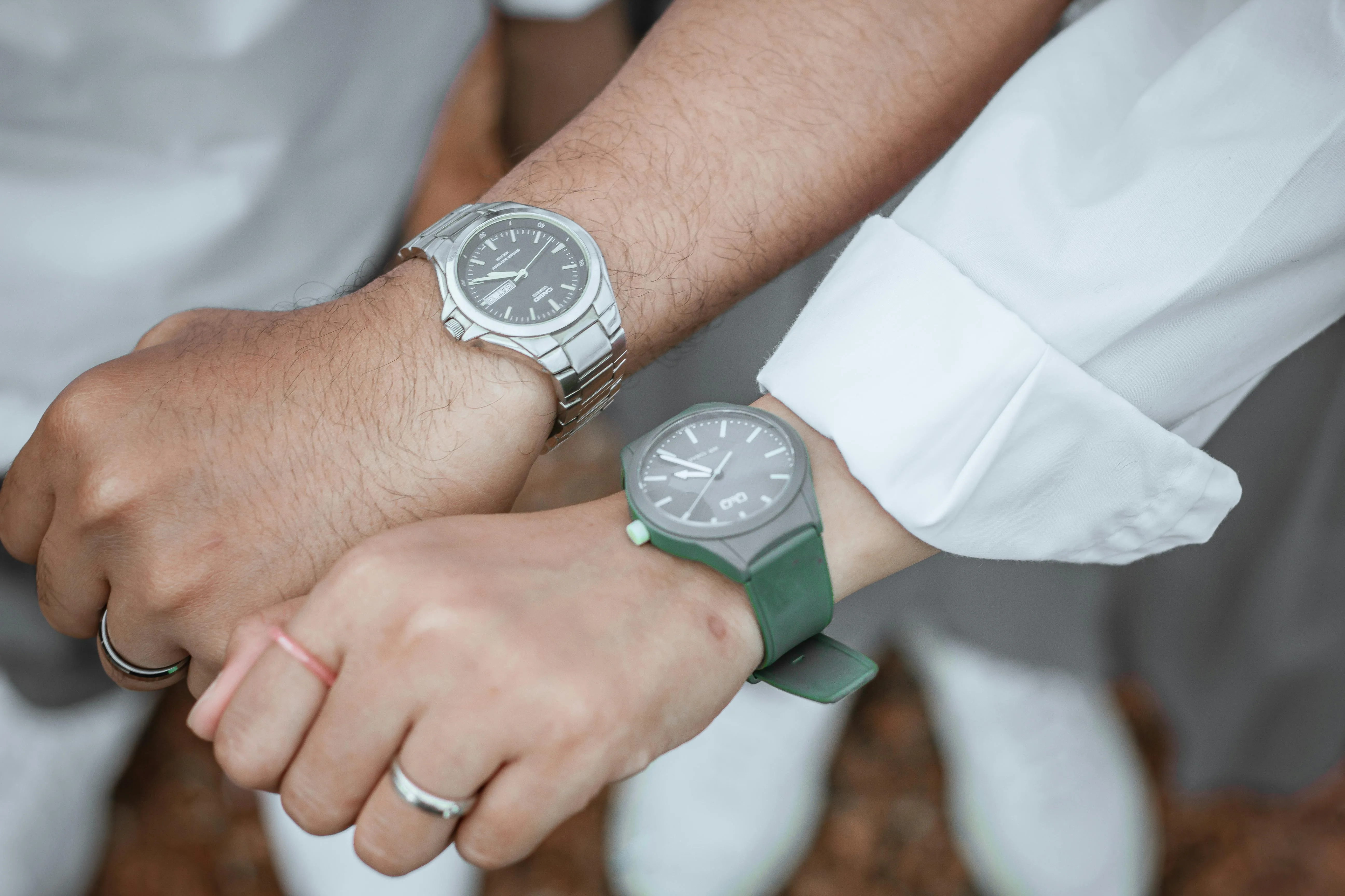Image de 2 montres portées par un poignet de femme et un poignet d'homme
