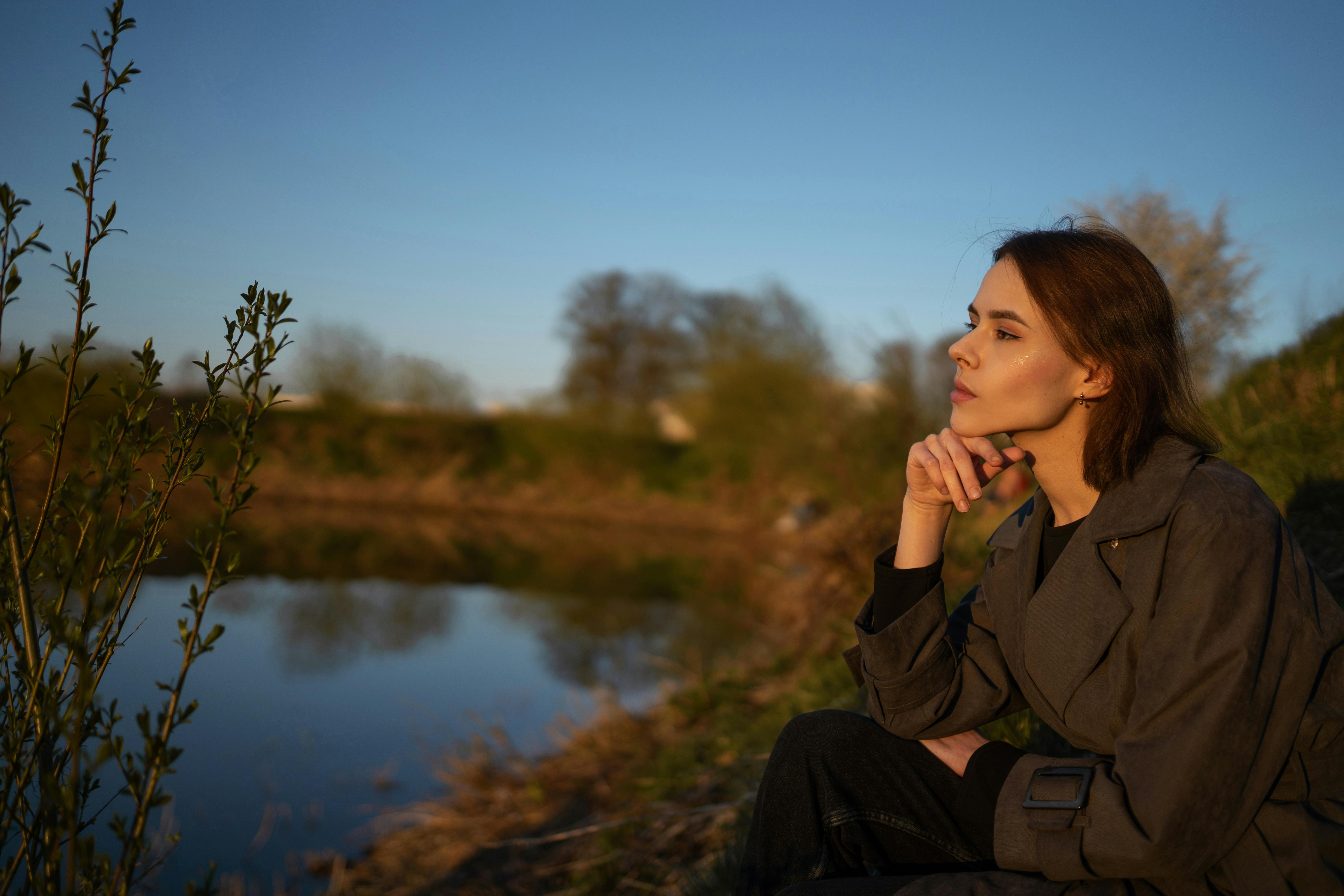 Infographie d'une femme en réflexion dans la nature face à un lac 